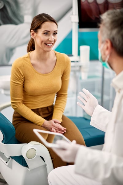young-happy-woman-talking-to-her-dentist-at-dental-2024-12-13-20-30-08-utc